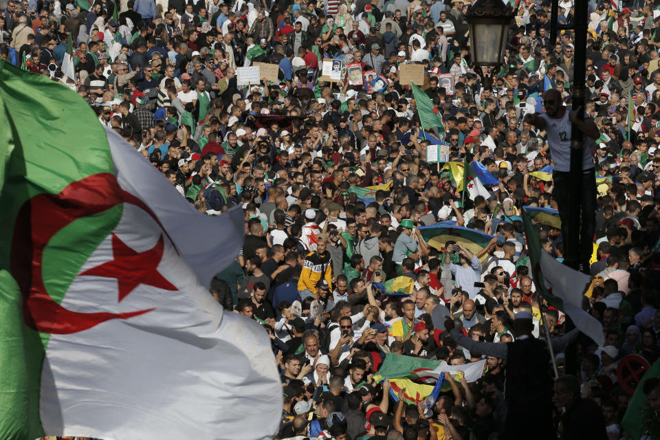 Algerian demonstrators take to the streets in the capital Algiers to protest against the government, in Algeria, Friday, Nov. 1, 2019. Police struggled Friday to contain thousands of Algerian demonstrators surging through the streets of the capital to protest next month's presidential election and celebrate 65 years since Algeria's war for independence from France. (AP Photo/Toufik Doudou)