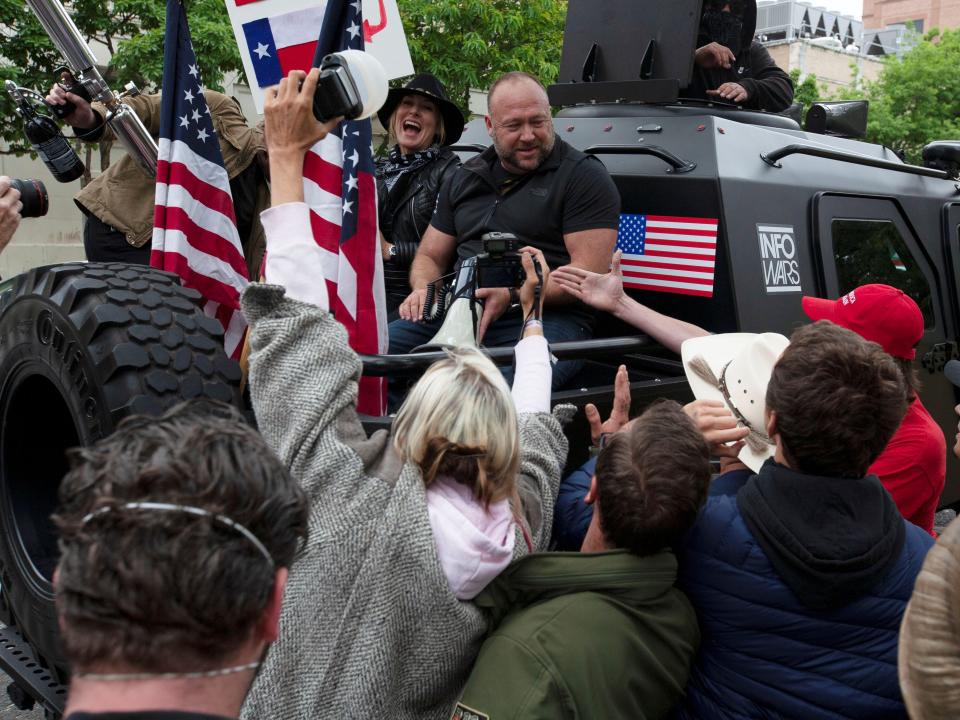 Alex Jones posing with military vehicle