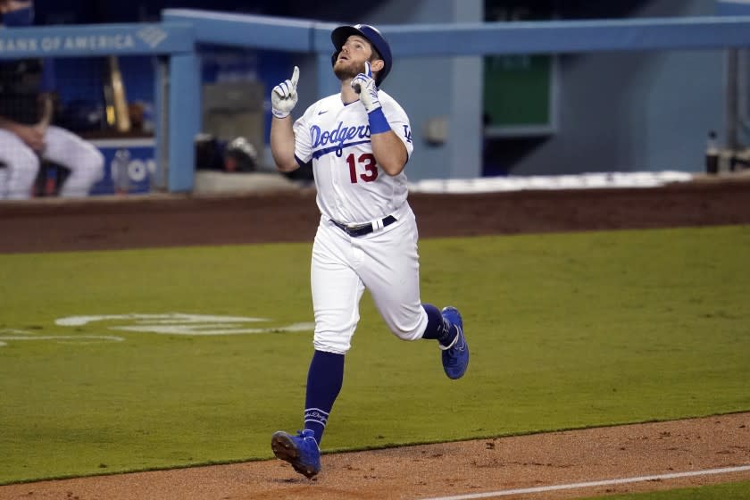 Los Angeles Dodgers' Max Muncy points as he nears home plate after his two-run home run.