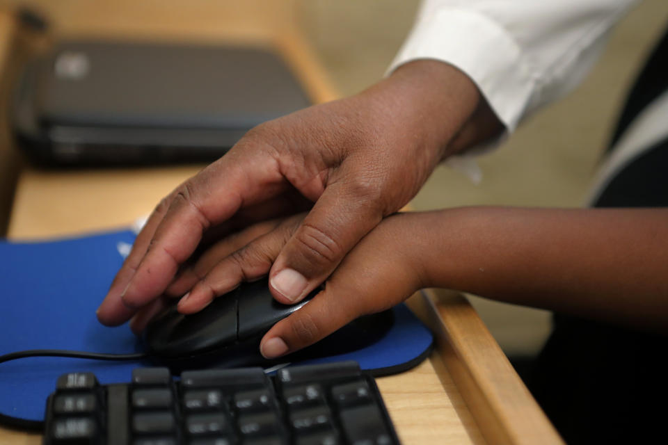 Sister Andria Donald of the Sisters of the Holy Family guides the hand of Irvin Jackson, 4, on a computer mouse during lessons at the St. John Berchmans Early Childhood Care Center in New Orleans, Thursday, July 23, 2020. At present, there are about 3 million African American Catholics, roughly 4% of the nation’s 69 million Catholics. (AP Photo/Gerald Herbert)