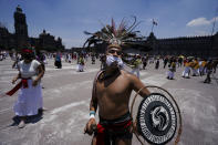 Bailarines participan en una ceremonia para conmemorar el 700 aniversario de la fundación de la ciudad azteca de Tenochtitlan, hoy conocida como Ciudad de México, en la Plaza del Zócalo, en la Ciudad de México, el 26 de julio de 2021, en plena pandemia del coronavirus. (AP Foto/Fernando Llano)