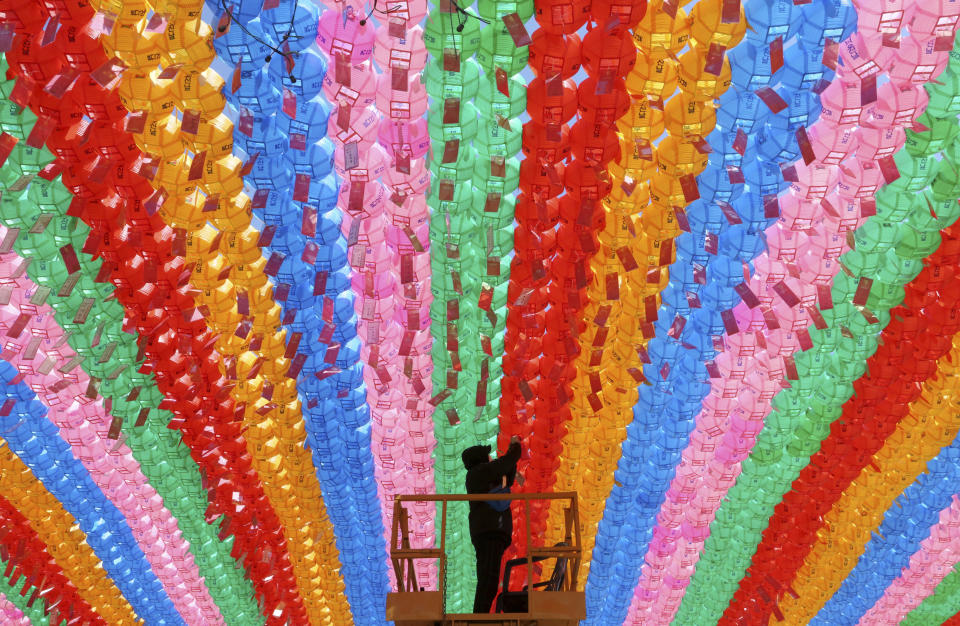 In this March 13, 2019, photo, a worker attaches a name tag of a Buddhist who made donation to a lantern for the upcoming celebration of Buddha's birthday on May 12 at the Jogye temple in Seoul, South Korea. Similar lanterns will be displayed in all Buddhist temples around South Korea for the public viewing. (AP Photo/Ahn Young-joon)