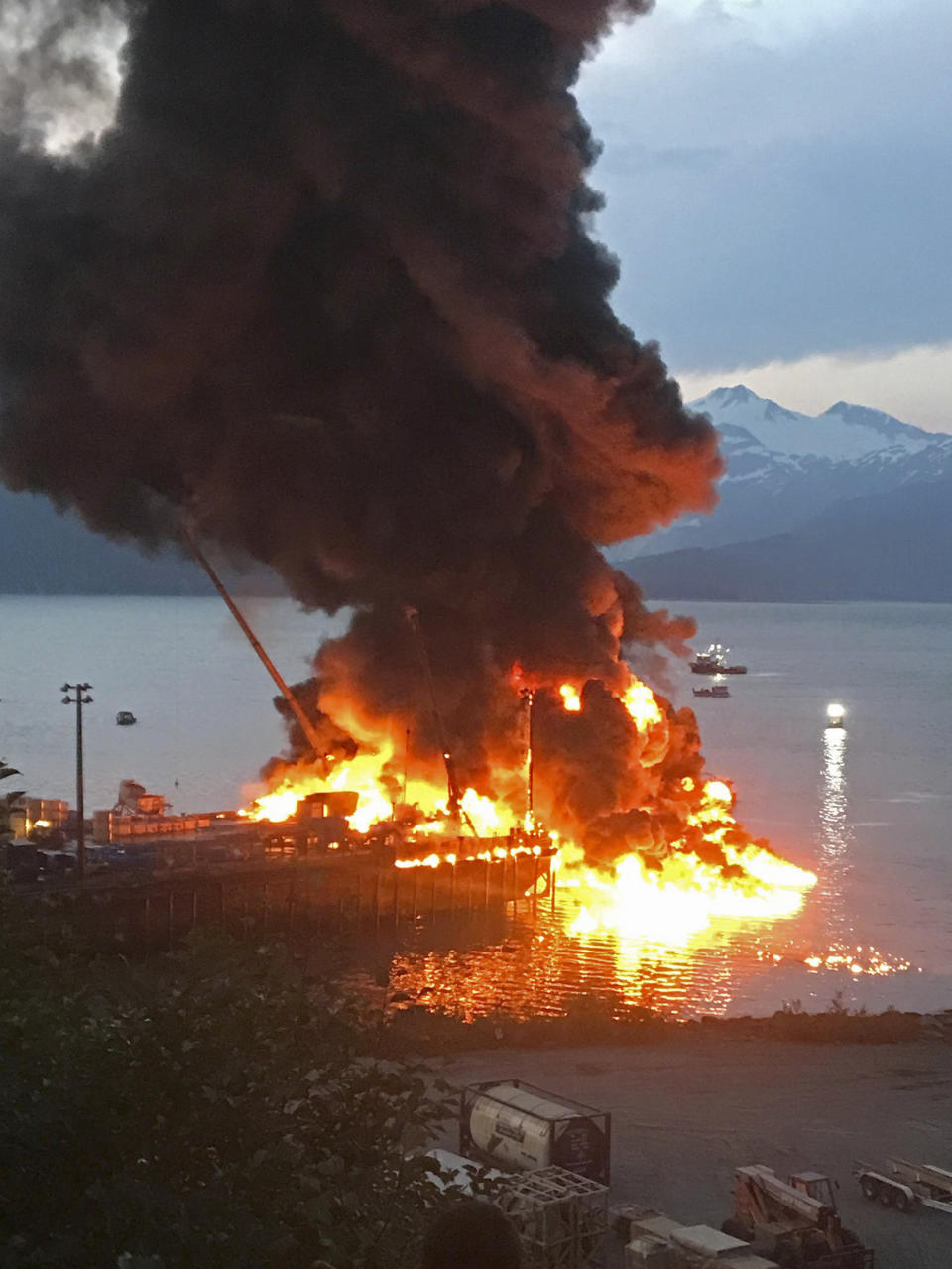 In this photo provided by the Girdwood Fire Department Monday, July 8, 2019, is an explosion that rocked a fishing boat tied up at a dock in Whittier, Alaska and spread fire to a nearby fishing boat that then sank, leaving one person aboard missing, the U.S. Coast Guard said Monday, July 8, 2019. (Brian Hicks/Girdwood Fire Department via AP)