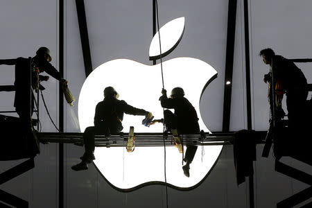 Workers prepare for the opening of an Apple store in Hangzhou, Zhejiang province, January 23, 2015. REUTERS/Chance Chan/File Photo