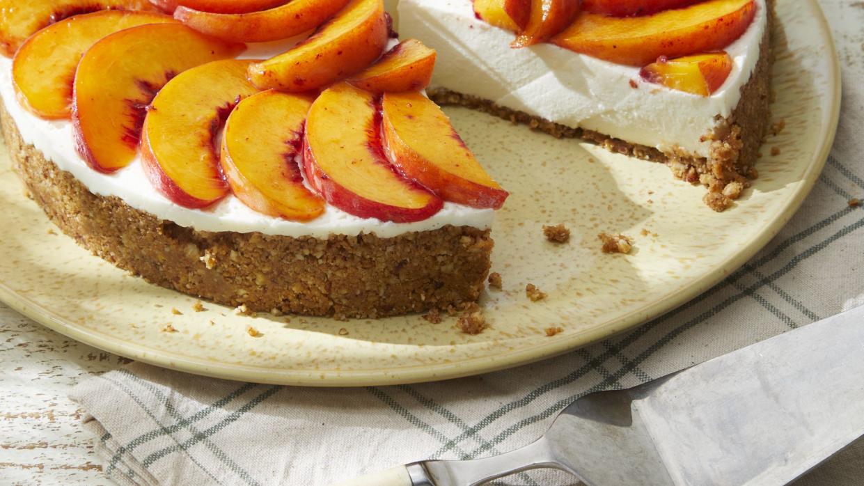 a no bake peach cheesecake with fruit on top