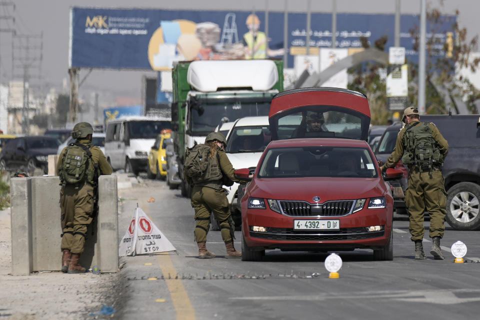 Israeli soldiers search Palestinian's car after Monday's shooting attack took place on a main highway near the Dead Sea and the West Bank Palestinian town of Jericho, Tuesday, Feb. 28, 2023. Israeli authorities says the motorist killed by a suspected Palestinian gunman in the occupied West Bank held citizenship in both the United States and Israel. (AP Photo/Majdi Mohammed)