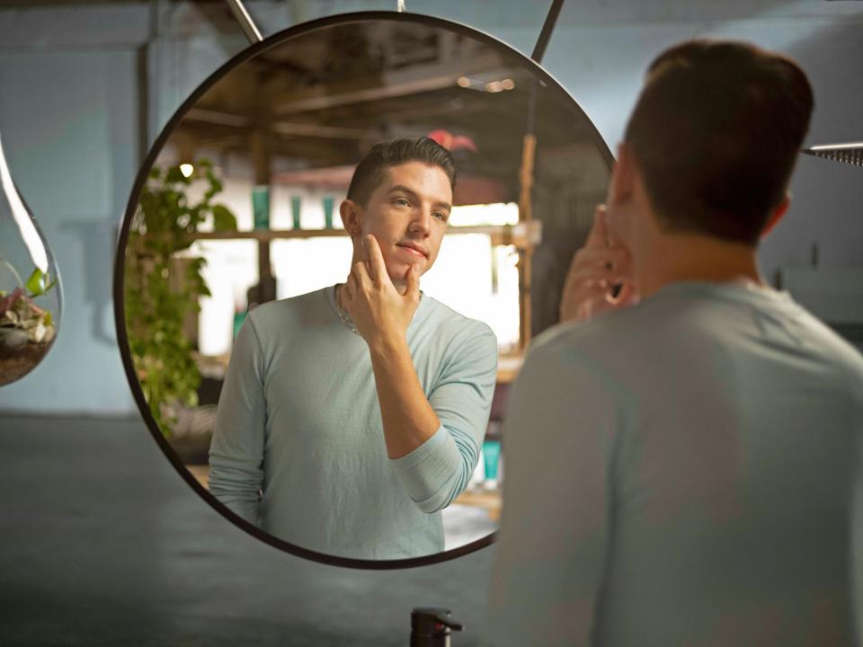 Hyram Yarbro, a skincare influencer, looks in a mirror.