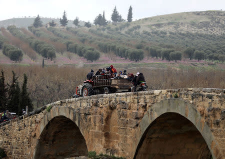 People sit in a truck with their belongings in the north east of Afrin, Syria March 15, 2018. REUTERS/Khalil Ashawi