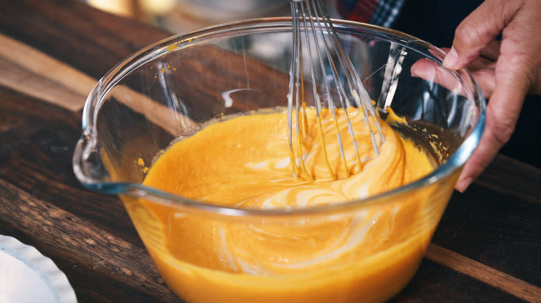 whisking pumpkin puree in bowl