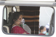 A COVID-19 patient waits inside an ambulance to be attended to and admitted into a dedicated COVID-19 government hospital in Ahmedabad, India, Thursday, April 22, 2021. A fire killed 13 COVID-19 patients in a hospital in western India early Friday as an extreme surge in coronavirus infections leaves the nation short of medical care and oxygen. India reported another global record in daily infections for a second straight day Friday, adding 332,730 new cases. The surge already has driven its fragile health systems to the breaking point with understaffed hospitals overflowing with patients and critically short of supplies. (AP Photo/Ajit Solanki)