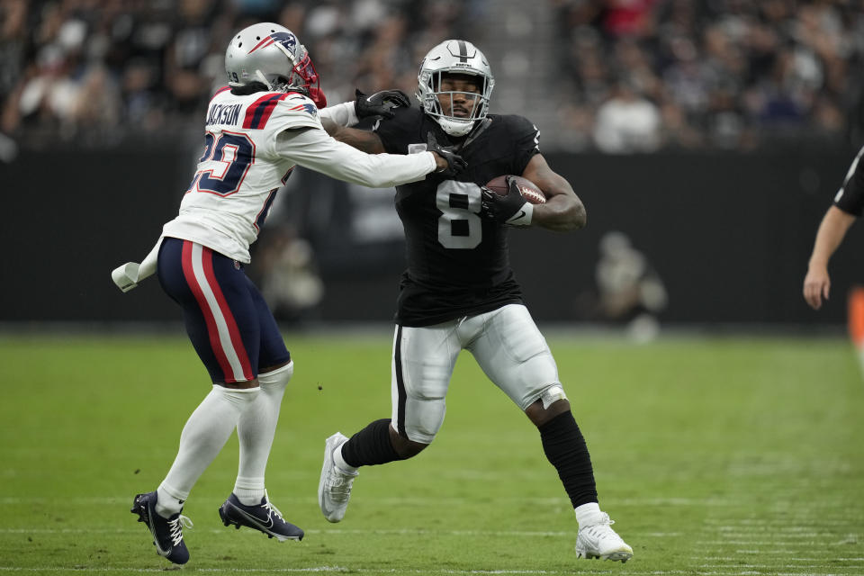 Las Vegas Raiders running back Josh Jacobs, right, runs with the ball as New England Patriots cornerback J.C. Jackson defends during the first half of an NFL football game Sunday, Oct. 15, 2023, in Las Vegas. (AP Photo/John Locher)