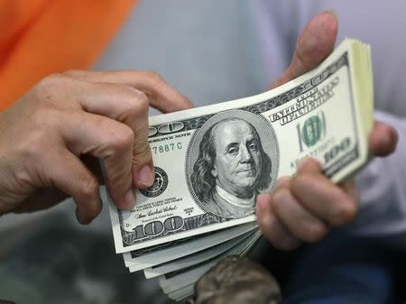 A woman counts her U.S. dollar bills at a money changer in Jakarta June 13, 2012. REUTERS/Beawiharta