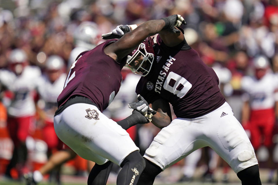 Texas A&M defensive linemen Micheal Clemons (2) and DeMarvin Leal (8) react after sacking New Mexico quarterback Terry Wilson (2) for an 8-yard loss during the first half of an NCAA college football game on Saturday, Sept. 18, 2021, in College Station, Texas. (AP Photo/Sam Craft)