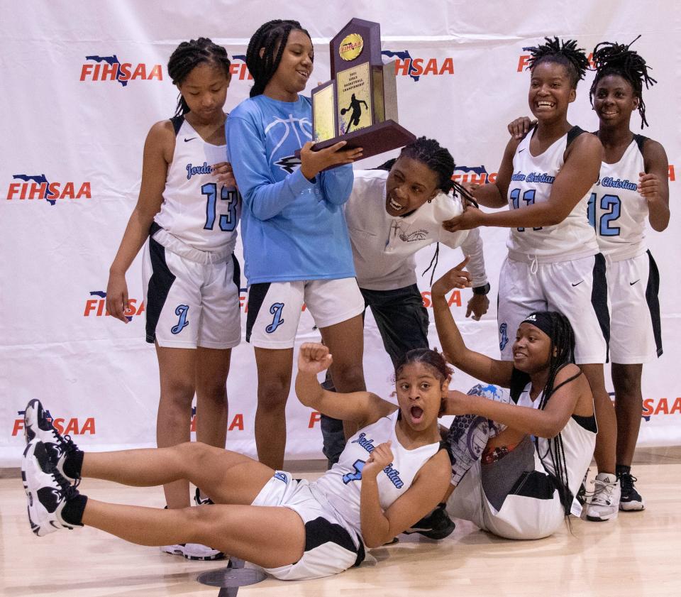 The Jordan Christian Prep girls basketball team holds the trophy after winning the FIHSAA state title on Friday afternoon at Webber International.