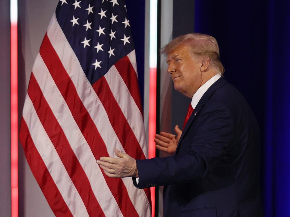 ORLANDO, FLORIDA - FEBRUARY 28: Former President Donald Trump embraces the American flag as he arrives on stage to address the Conservative Political Action Conference held in the Hyatt Regency on February 28, 2021 in Orlando, Florida. Begun in 1974, CPAC brings together conservative organizations, activists, and world leaders to discuss issues important to them. (Photo by Joe Raedle/Getty Images)
