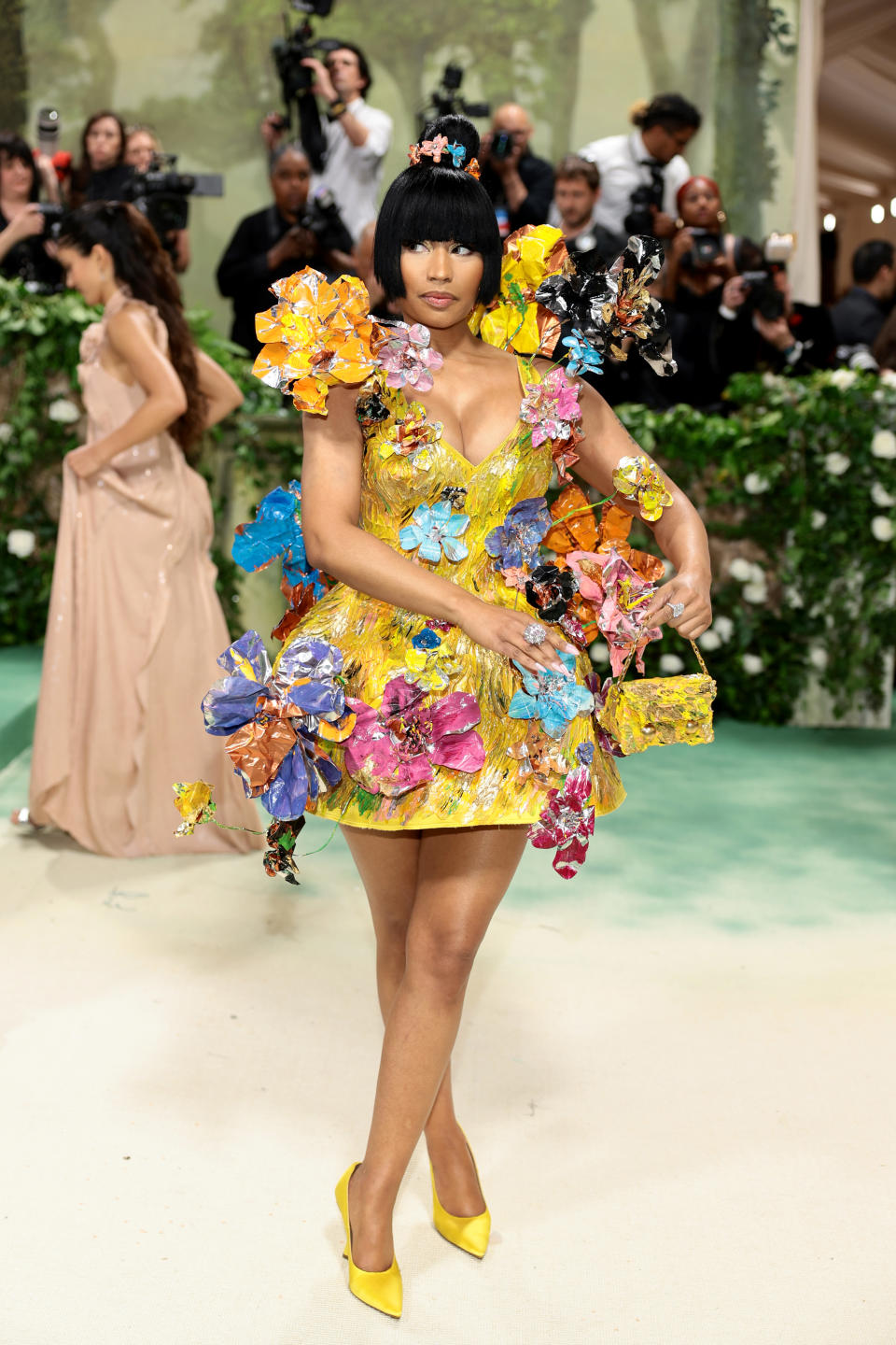 Nicki Minaj in a yellow dress covered in flowers at the Met Gala red carpet.