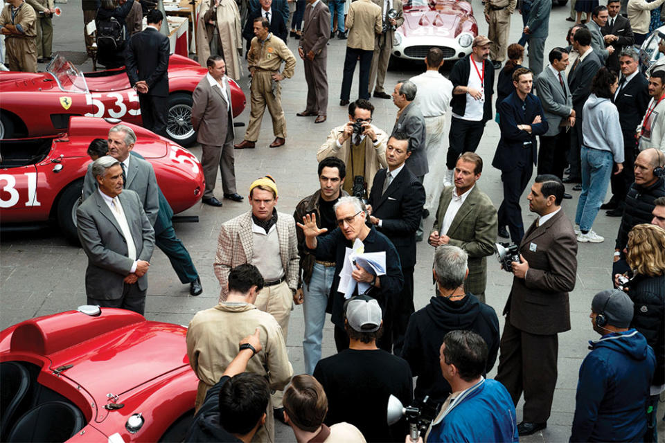 Michael Mann center, in glasses on set in Italy, surrounded by custom-built reproductions of Ferrari and Maserati cars driven in the 1957 Mille Miglia race.