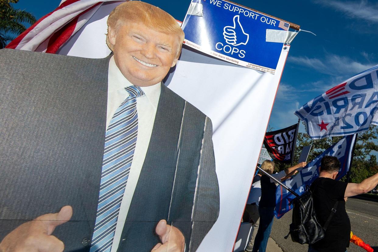 Supporters of Donald Trump hold up a cardboard cutout of the former president outside the Reagan library where the debate was.