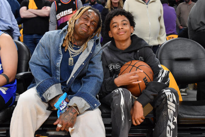LOS ANGELES, CALIFORNIA - OCTOBER 26: Lil Wayne (L) and his son Kameron Carter attend a basketball game between the Los Angeles Lakers and the Phoenix Suns at Crypto.com Arena on October 26, 2023 in Los Angeles, California. | Photo by Allen Berezovsky/Getty Images