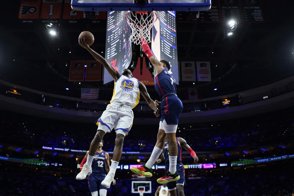 Golden State Warriors' Andrew Wiggins (22) goes up for a shot past Philadelphia 76ers' KJ Martin (1) during the first half of an NBA basketball game, Wednesday, Feb. 7, 2024, in Philadelphia. (AP Photo/Matt Slocum)