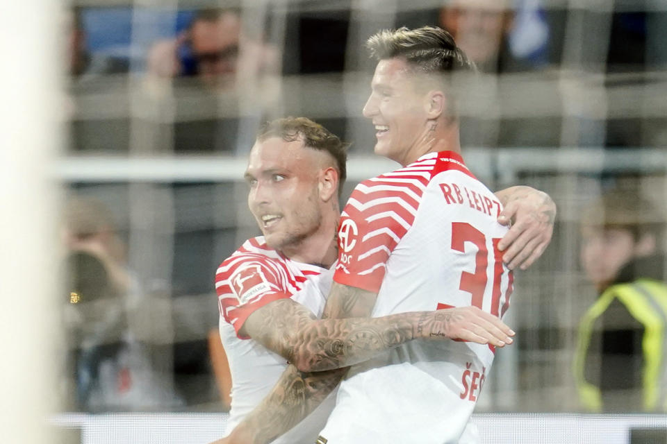 Leipzig's Benjamin Sesko, right, celebrates scoring with teammte David Raum during the Bundesliga soccer match between TSG 1899 Hoffenheim and RB Leipzig at PreZero Arena, Sinsheim, Germany, Friday May 3, 2024. (Uwe Anspach/dpa via AP)