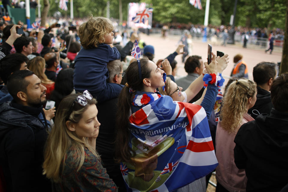 People gather on the Mall in central London, Sunday June 5, 2022 to watch the Platinum Jubilee Pageant, on the last of four days of celebrations to mark the Platinum Jubilee. The pageant will be a carnival procession up The Mall featuring giant puppets and celebrities that will depict key moments from the Queen Elizabeth II's seven decades on the throne.(AP Photo/David Cliff)