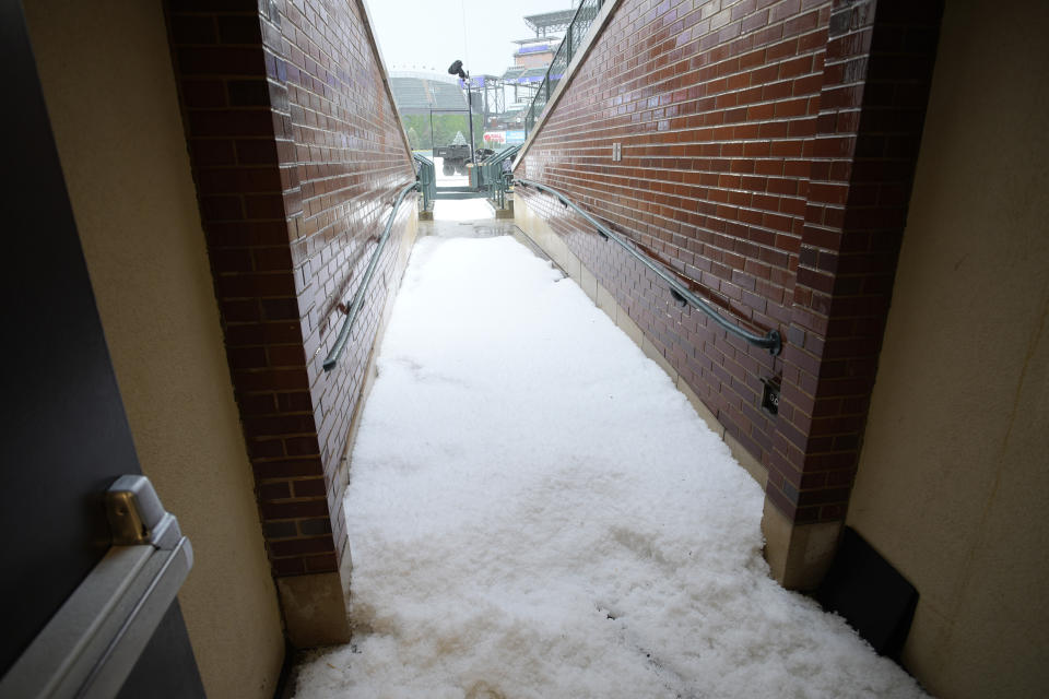Hail fills the walkway to the diamond of Coors Field after a summer storm packing heavy rain, high winds and large hail swept over the stadium Thursday, June 29, 2023, in Denver. The Colorado Rockies were set to host the Los Angeles Dodgers, Thursday. (AP Photo/David Zalubowski)