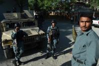 Afghan policemen stand along a street near the Heetal Hotel in Kabul, on May 27, 2015