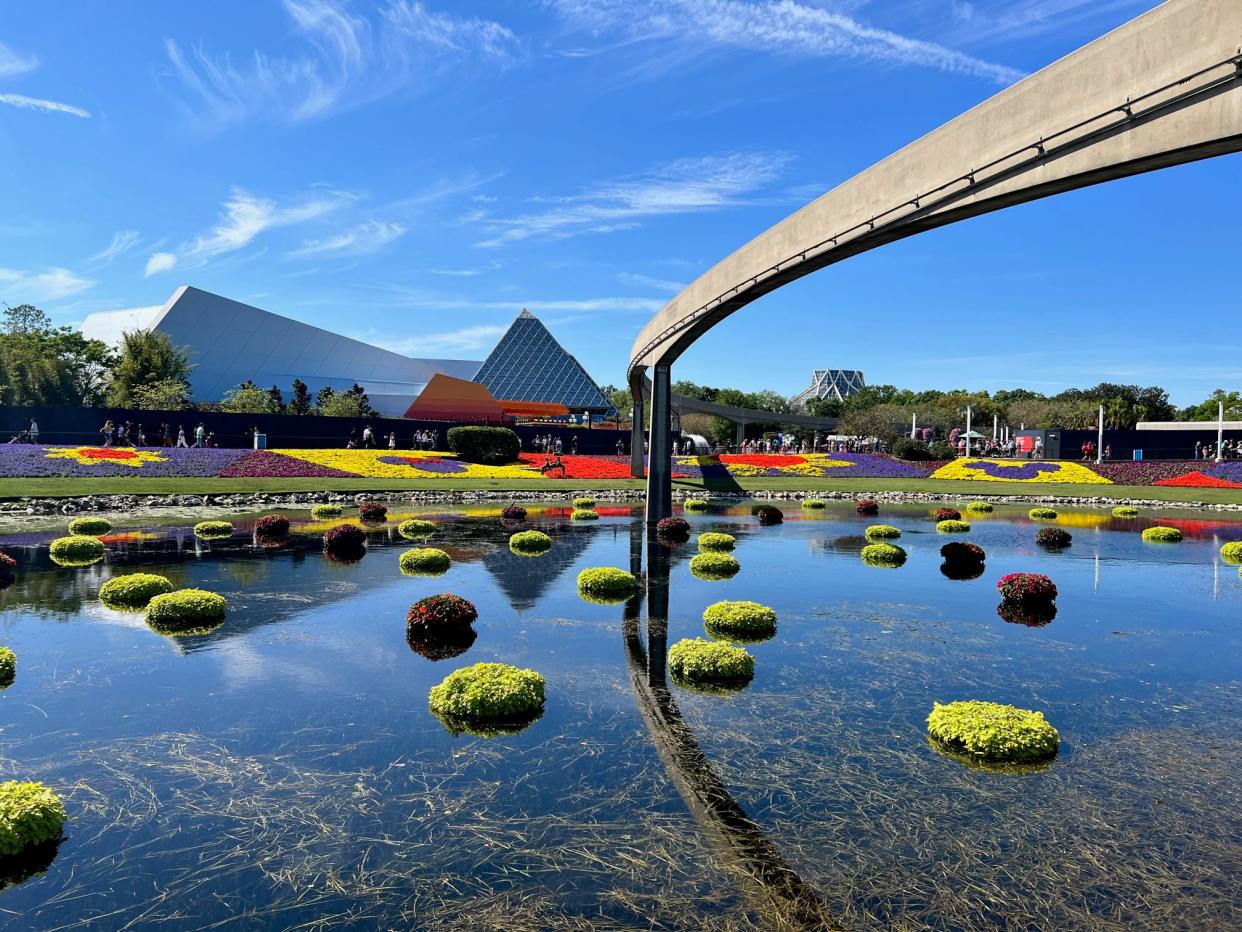 Colorful flowers bejewel the lawn near Journey into Imagination with Figment and The Land during EPCOT International Flower & Garden Festival.