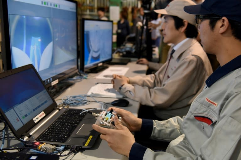 Employees of Japan's Toshiba attempt to navigate a remotely operated underwater vehicle (ROV), developed by Toshiba and the International Research Institute for Nuclear Decommissioning (IRID)