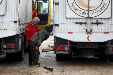 A rebel fighter inspects Red Crescent vehicles on their way to al Foua and Kefraya, in Idlib province, Syria January 11, 2016. REUTERS/Ammar Abdullah