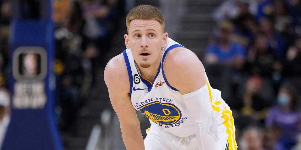 Donte DiVincenzo rests with his hands on his knees while looking up during a Warriors game in 2022.