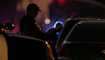 A law enforcement officer mans a barricade near a home that authorities have surrounded where an armed suspect has taken refuge after shooting a Sacramento police officer, Wednesday, June 19, 2019, in Sacramento, Calif. (AP Photo/Rich Pedroncelli)