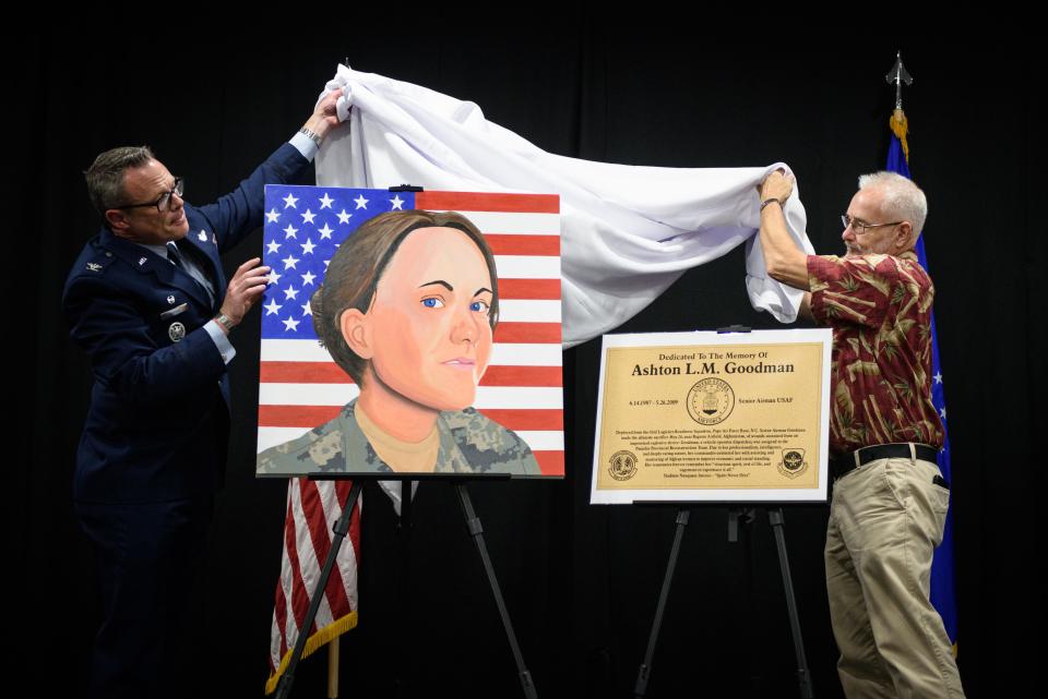 Col. Allen Morris Jr., left, and retired Master Sgt. Mark Goodman unveil a portrait and plaque honoring Senior Airman Ashton Lynn Marie Goodman during a building dedication ceremony at Pope Army Airfield on Friday, June 21, 2024. Pope Army Airfield dedicated the Airman’s Center building in honor of Senior Airman Goodman, who served at Pope Air Force Base from 2006 until her death in 2009 while deployed to Afghanistan.