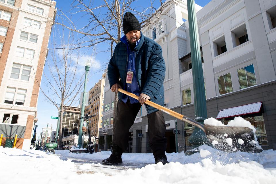 Lelon Armstrong Jr., who works in maintenance for Parkway, shovels snow off the sidewalk in front of a parking lot in Downtown Memphis, Tenn., on Tuesday, January 16, 2024.