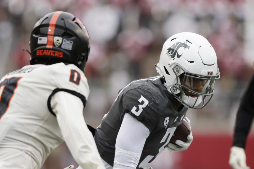 Washington State wide receiver Josh Kelly (3) carries the ball while pressured by Oregon State defensive back Akili Arnold (0) during the first half of an NCAA college football game, Saturday, Sept. 23, 2023, in Pullman, Wash. (AP Photo/Young Kwak)