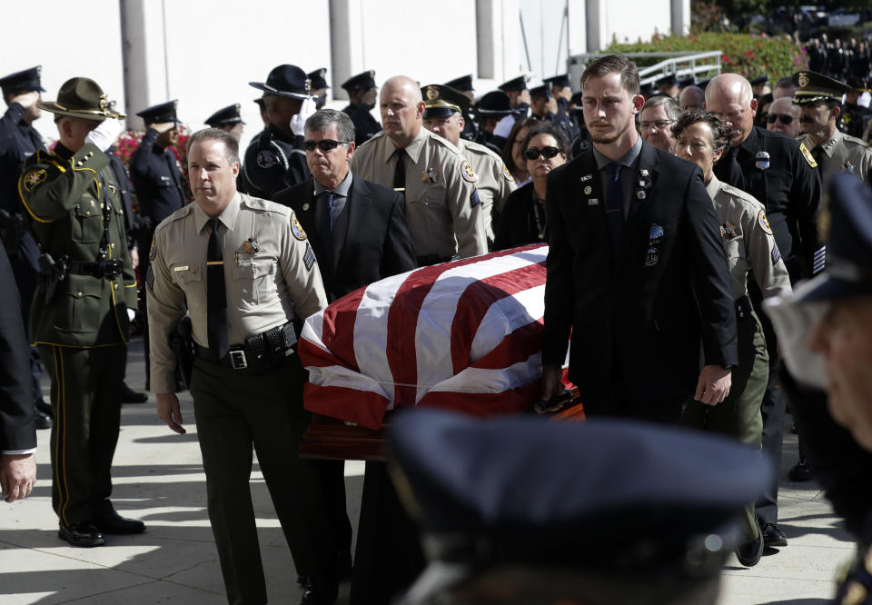 A casket with the body of Ventura County Sheriff's Sgt. Ron Helus is carried into the Calvary Community Church Thursday, Nov. 15, 2018, in Westlake Village, Calif. Helus was fatally shot while responding to a mass shooting at a country music bar in Southern California. (AP Photo/Marcio Jose Sanchez, Pool)