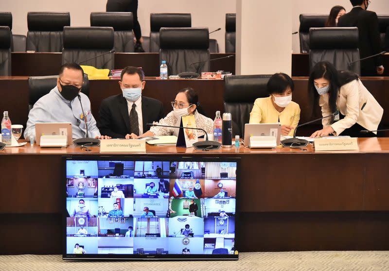 Government senior officials, wearing protective face masks due to the coronavirus disease (COVID-19) outbreak, attend a teleconference for a weekly cabinet meeting with ministers at the Government House in Bangkok