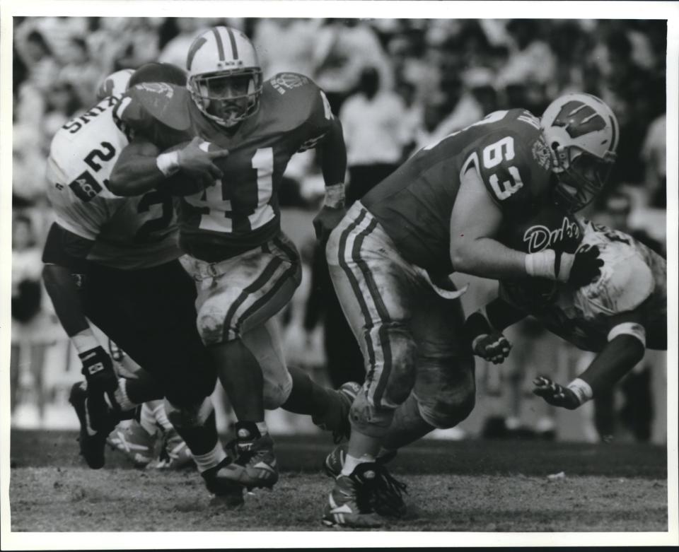 Tailback Terrell Fletcher scoots for some of his 241 yards on 39 carries in the Hall of Fame Bowl as senior guard Joe Rudolph helps clear the way.