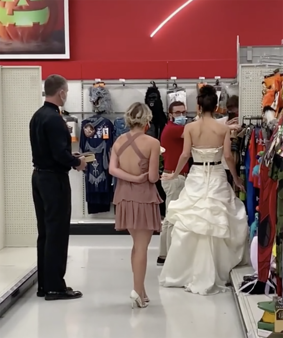 A woman dressed in a wedding dress has been caught on camera storming into a Target store, demanding her fiancé who works in the store marry her there and then or she'll break up with him. Photo: TikTok/@boymom_ashley