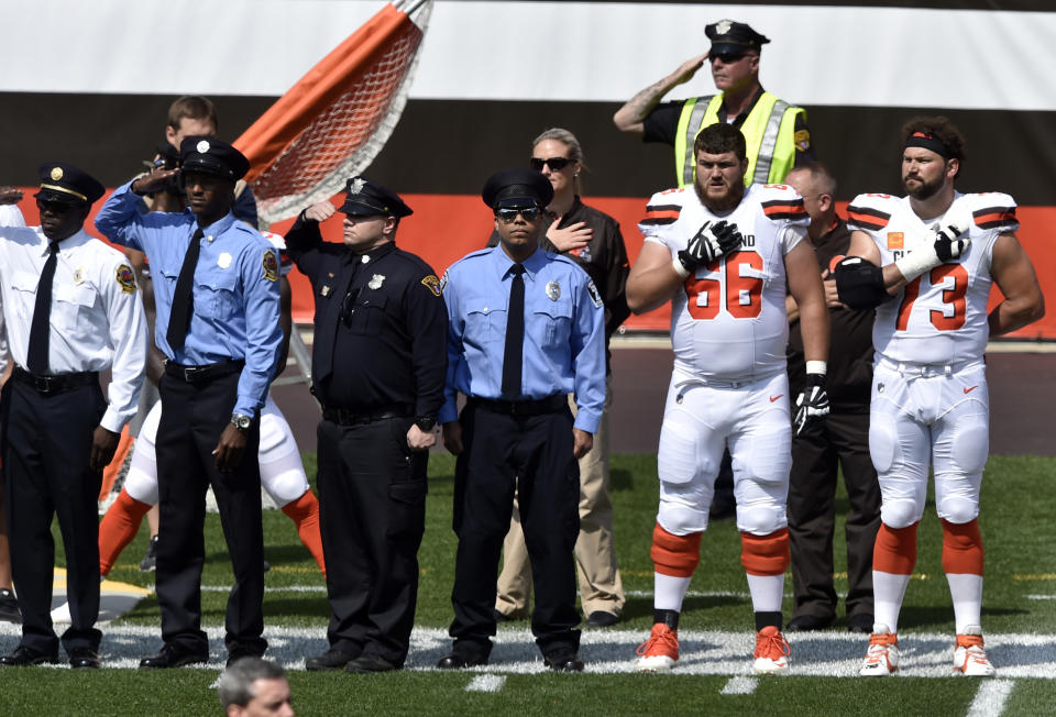 Members of the Cleveland police and the Cleveland Browns players stand together during the national anthem. (AP)