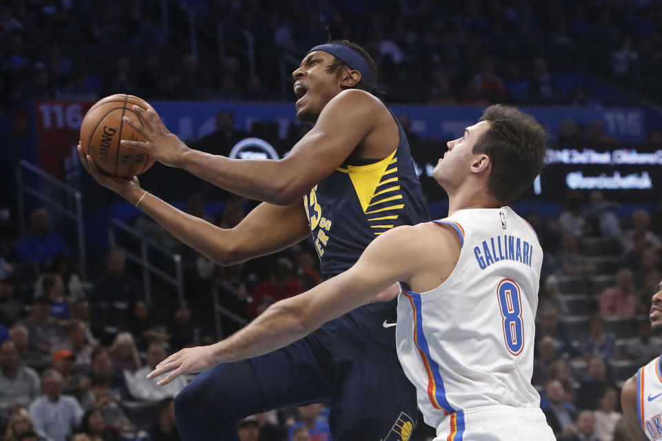 Indiana Pacers center Myles Turner, left, goes to the basket in front of Oklahoma City Thunder forward Danilo Gallinari (8) during the first half of an NBA basketball game Wednesday, Dec. 4, 2019, in Oklahoma City. (AP Photo/Sue Ogrocki)