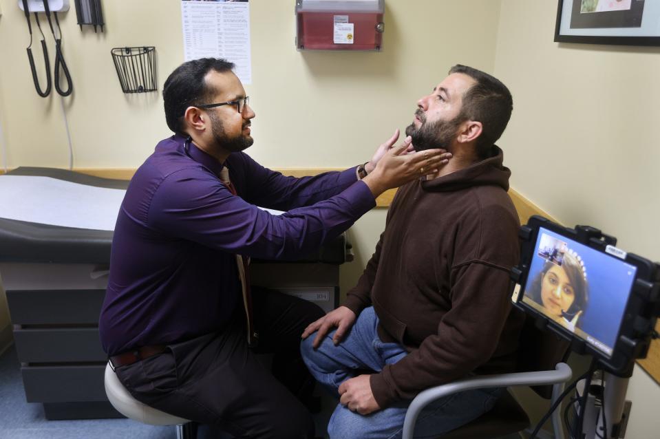Naser Albarazanchi, who came to the U.S. from Jordan after fleeing his native war-torn Iraq, visits with Dr. Nidun Daniel at The Center for Refugee Health, part of Rochester Regional Health.