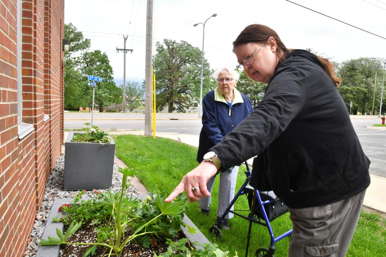 Volunteers Janice Rein and Claire Garcia talk about plantings Tuesday, May 31, 2022, in a garden area near the Waite Park Public Library. 