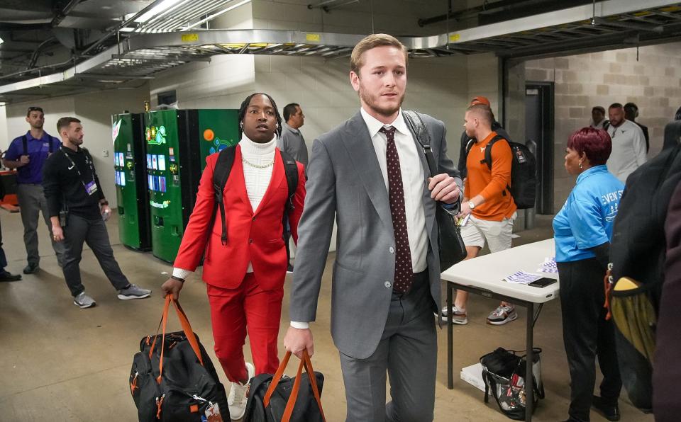 Texas quarterback Quinn Ewers makes his way to the locker room inside Amon G. Carter Stadium in Fort Worth on Saturday. He'll start the game after missing the last two weeks with a shoulder injury. Texas is favored to win by 12 points.