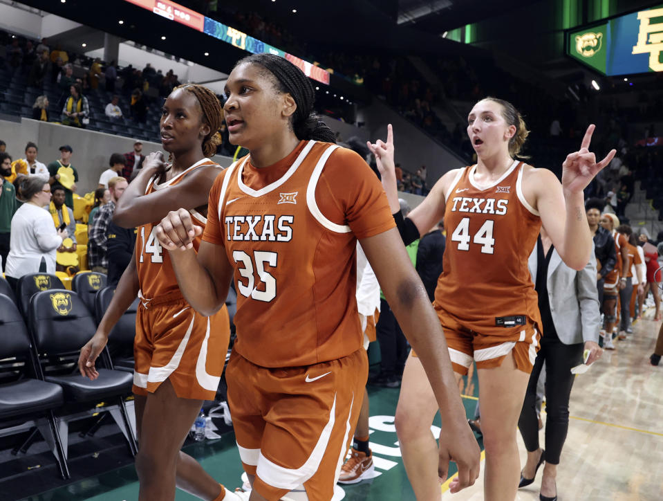Texas forward Madison Booker, center, leaves the court with teammates Amina Muhammad, left, and Taylor Jones, right, after defeating Baylor following an NCAA college basketball game, Thursday, Feb. 1, 2024, in Waco, Texas. (Rod Aydelotte/Waco Tribune-Herald via AP)