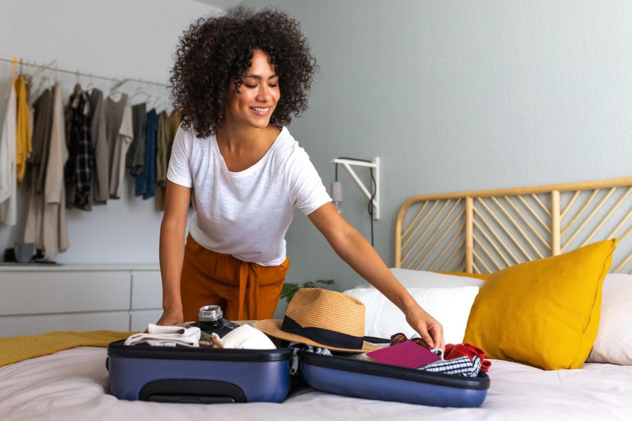 young woman packing suitcase