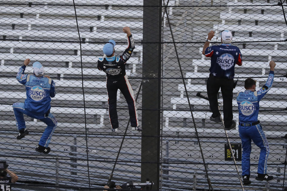 Kevin Harvick, second from left, and some members of the team's crew climb the fence after Harvick won the NASCAR Cup Series auto race at Indianapolis Motor Speedway in Indianapolis, Sunday, July 5, 2020. (AP Photo/Darron Cummings)