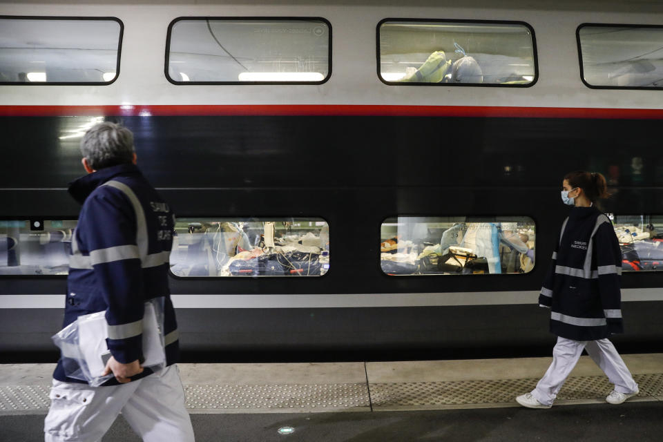 Medical staff leave after embarking patients infected with the COVID-19 virus in a train at the Gare d'Austerlitz train station Wednesday April 1, 2020 in Paris. France is evacuating 36 patients infected with the coronavirus from the Paris region onboard two medicalized high-speed TGV trains. The patients, all treated in intensive care units (ICU), are being transferred to several hospitals in Britany, as western France is less impacted by the epidemic. The new coronavirus causes mild or moderate symptoms for most people, but for some, especially older adults and people with existing health problems, it can cause more severe illness or death. (Thomas Samson, Pool via AP)