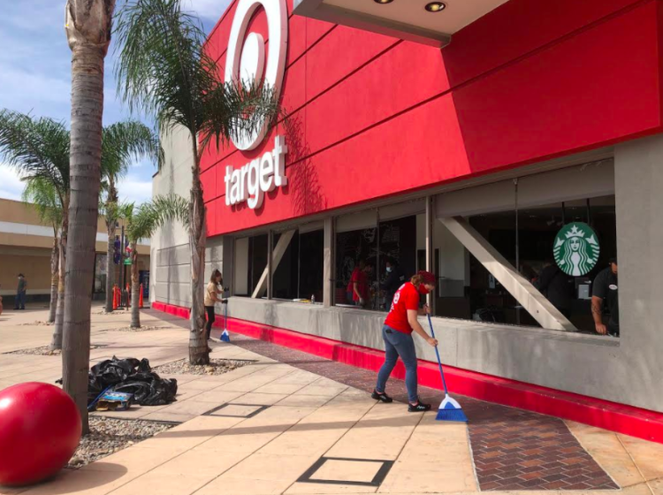 Workers clean up broken glass on Sunday at the Target store at Grossmont Center in La Mesa.